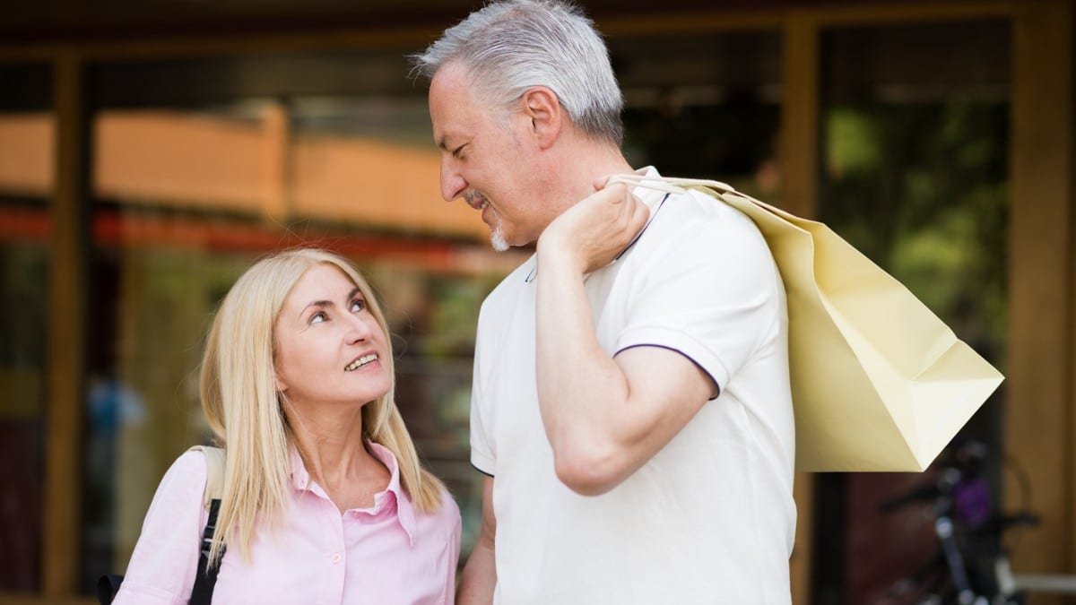 15 Smart Ways Retirees Cut Costs Quietly senior couple with shopping bag