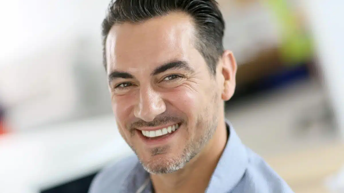 man smiling at his home