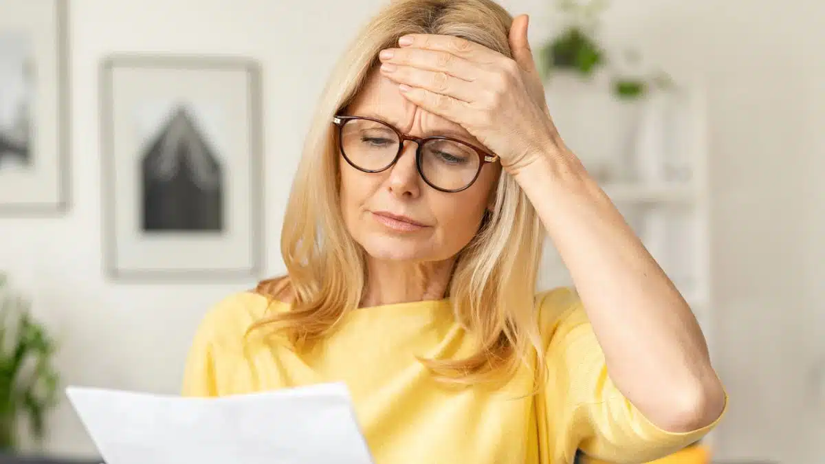 woman glasses reading mail living room